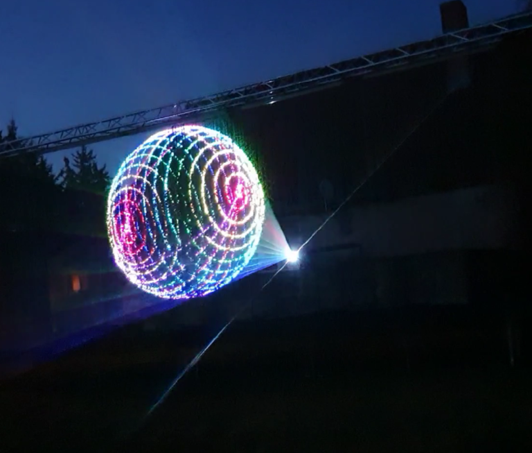 Eine Laserprojektion auf eine 10 Meter lange Wasserleinwand zusehen ist ein 3D Animation einer Gitterkugel.